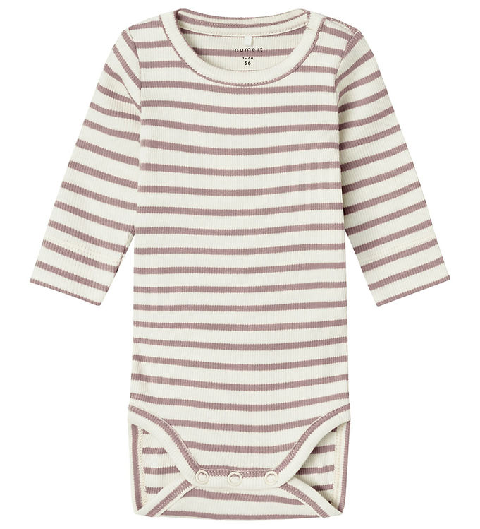 Oplev skønheden i Name It Body Rib Bani Striber Deauville Mauve – en perfekt kombination af komfort og stil til de mindste. Denne body i blød ribstrik er designet med en smuk mauve farve og diskrete striber, der giver et moderne udtryk. Den økologiske bomuldsblanding sikrer en behagelig pasform, mens de praktiske trykknapper gør på- og aftagning let. Perfekt til både hverdag og fest giver denne body dit barn frihed til at bevæge sig.

- Blød og komfortabel ribstrik
- Økologisk bomuldsblanding
- Trendy stribedesign i mauve
- Praktiske trykknapper
- Ideel til både hverdag og fest
- Giver bevægelsesfrihed til dit barn